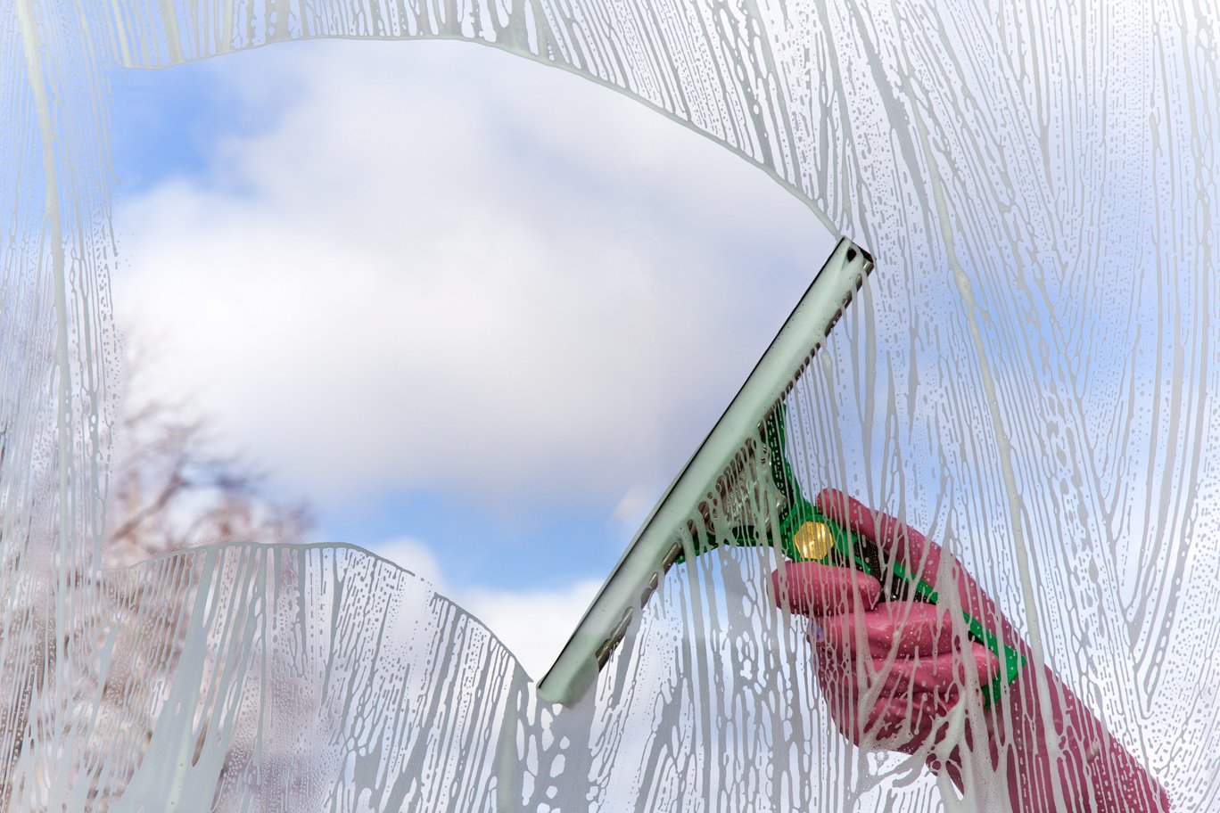 Early spring windows cleaning. Maid cleans window.